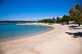 Piesočnato-kamienková pláž Punat - ostrov Krk, Chorvátsko