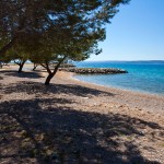 Punat - piesočnato okrúhliaková pláž, ostrov Krk, Chorvátsko